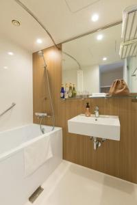仙北Tazawako Lake Resort & Onsen / Vacation STAY 78938的一间带水槽、浴缸和镜子的浴室