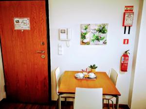 丰沙尔Casa dos Avós Apartments的一间设有桌子和红色门的房间,以及一张桌子和椅子