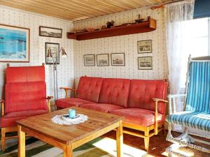 格雷伯斯塔德5 person holiday home in GREBBESTAD的客厅配有红色沙发和咖啡桌