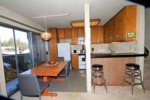 马姆莫斯湖Sierra Park Villas #24的带木桌和椅子的厨房以及带柜台的厨房。