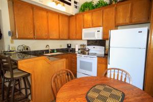 马姆莫斯湖Sierra Park Villas #88的厨房配有白色冰箱和桌子