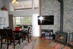 马姆莫斯湖Sierra Park Villas #03的一间客厅,客厅内配有桌子和砖墙上的电视