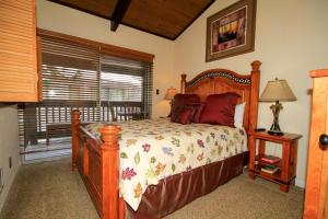 马姆莫斯湖Sierra Park Villas #82的一间卧室设有一张木床和一个窗户。