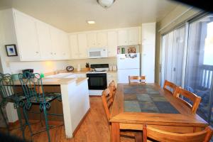 马姆莫斯湖Sierra Park Villas #16的厨房以及带桌椅的用餐室。