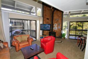 马姆莫斯湖Sierra Park Villas #89的客厅配有红色椅子和电视