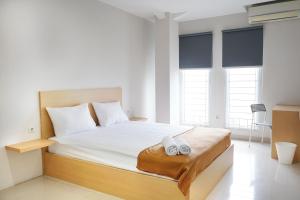 雅加达UROOMS Senayan的一间卧室配有一张床,上面有两条毛巾