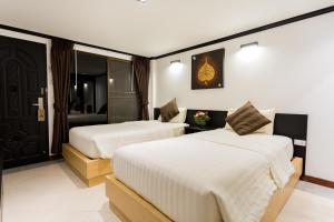 沙美岛沙美岛君怡度假酒店的酒店客房,设有两张床和镜子