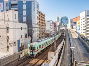 福冈西铁天神旅馆的城市中拥有建筑物的轨道上的火车