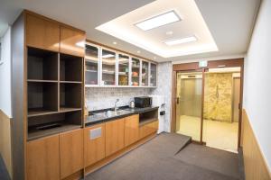 首尔明洞1号步伐旅舍的一个带木制橱柜和水槽的厨房