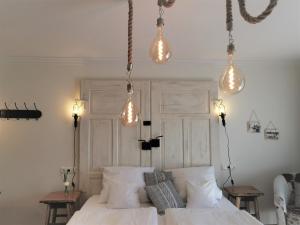 巴特比恩巴赫Zur Mühle的卧室配有白色床,上面有灯
