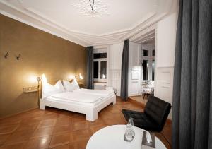 苏黎世好运旅馆的卧室配有白色的床和黑椅