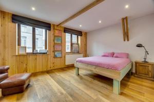 昂吉安maison familiale près de bruxelles et paridaisia的卧室配有粉红色的床和木地板