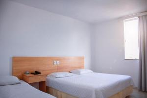 泰谢拉迪弗雷塔斯Pioneiro Hotel的一间卧室设有两张床和窗户。