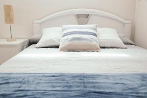 桑坦德Estilo nordico Sardinero的白色的床、白色床头板和枕头