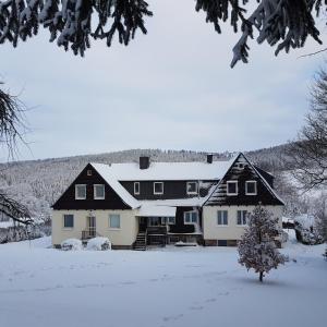Rechenberg-BienenmühleFerienwohnung Goldene Höhe的地面上积雪的大房子