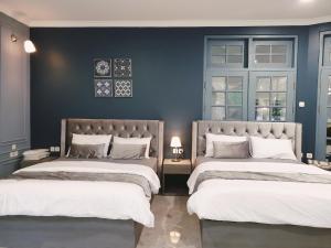 普卡Villa Airis By The Villas 100的卧室设有两张床铺和蓝色的墙壁