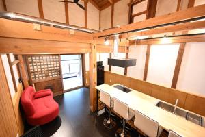 高山Manabi-stay Takayama モダンな蔵ダイニングと半露天風呂付き古民家一棟貸切ホテル的配有桌椅和红色椅子的房间
