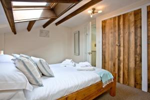 布德East Thorne - Cornwall的卧室配有白色的床和木门