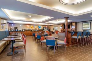 南希尔Comfort Inn & Suites South Hill I-85的一间带桌椅的餐厅和一间酒吧