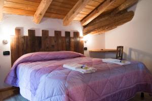 圣皮埃尔B&B Lo VAN - Camere al Verde Villaggio di Rumiod的一间卧室配有一张大床和木制床头板