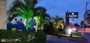 马塞约贾丁斯情趣酒店（仅限成人入住）的楼前有棕榈树的街道标志