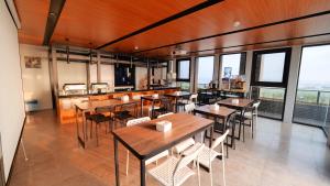 马公安泊海景旅店的餐厅设有木桌、椅子和窗户。