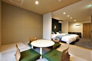 泉佐野Apartment Hotel STAY THE Kansai Airport的卧室配有一张床和一张桌子及椅子