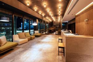 名古屋Sanco Inn Grande Nagoya -HOTEL & SPA-的大厅配有沙发,大楼内设有一间酒吧