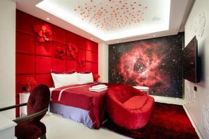 台中市极光情境旅馆的一间卧室配有红色的床和两把椅子