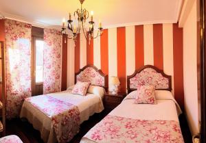 拉瓜迪亚La Casa de Begoña的橙色和白色条纹的客房内的两张床