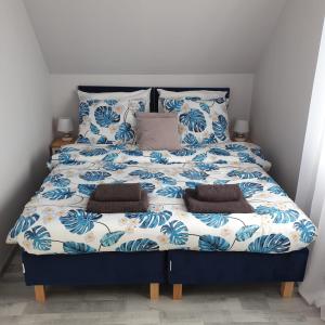 米兹多洛杰Top Alex domki Międzyzdroje的一张带蓝色和白色床单及枕头的床