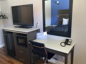 萨克拉门托Oasis Inn Sacramento- Elk Grove的客房设有一张带电视和镜子的书桌