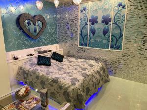 所泽市瑞斯戴所泽情趣酒店（仅限成人）的一间设有床铺的房间,墙上有心