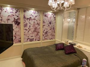 所泽市瑞斯戴所泽情趣酒店（仅限成人）的一间卧室设有一张床和鲜花墙