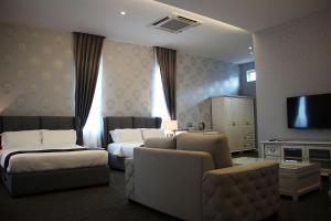 居銮卡萨比安卡酒店的酒店客房设有两张床、一张沙发和一台电视机。