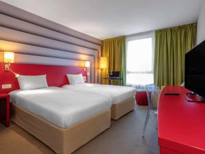 阿维尼翁南阿维农宜必思尚品酒店的酒店客房设有一张大床和红色的墙壁。