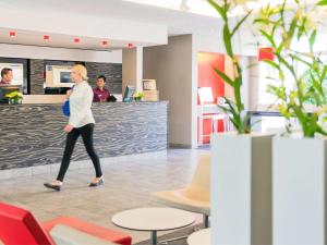圣罗兰度瓦诺沃特尼斯机场卡普3000酒店的一位妇女穿过办公室大厅