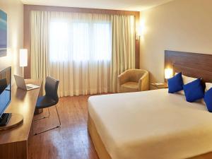 马瑙斯马瑙斯诺富特酒店的酒店客房设有一张大床和一张书桌。