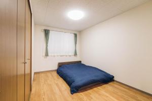 旭川STAY IN PASSION的一间卧室设有蓝色的床和窗户。
