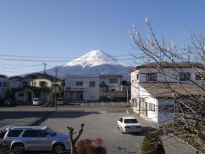 富士河口湖Fuji Kurasu 響的远处的雪覆盖的山,汽车停在停车场