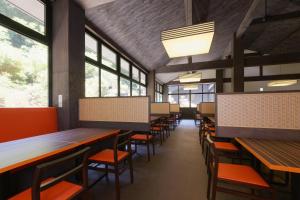 箱根仙石原芒草原一之汤日式旅馆的用餐室设有桌椅和窗户。