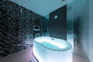 神户Hotel Eldia Modern Kobe(Adult Only)的带浴缸和玻璃淋浴间的浴室。