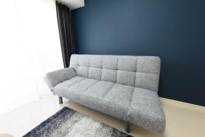 冈山Cocostay KO Residence Sennichimae#603ココステイ ケーオーレジデンス センニチマエ#603的蓝色墙壁的房间里一张灰色的沙发