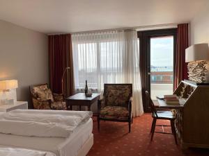 韦斯特兰武斯彻曼酒店的配有一张床、一张书桌和一扇窗户的酒店客房