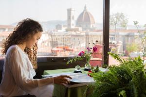 佛罗伦萨安缇卡托瑞迪维亚托尔纳布奥尼酒店的坐在桌子旁读书的女人