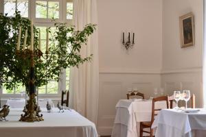 BenonManoir de Plaisance的一间用餐室,配有2张带白色桌布的桌子