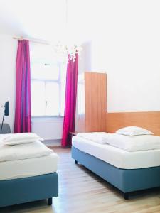 马克特雷德维茨巴里斯切霍夫酒店的卧室内的两张床,配有红色窗帘