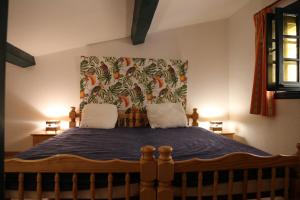 滨海巴纽尔斯LES PIEDS DAND L'EAU的一间卧室配有一张大床和花卉床头板