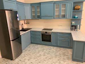 卡罗利诺-布加兹Апартаменты Золотой Бугаз的厨房配有蓝色橱柜和不锈钢冰箱