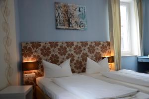 吕德斯海姆莱因斯坦酒店的一间卧室配有两张带白色枕头的床